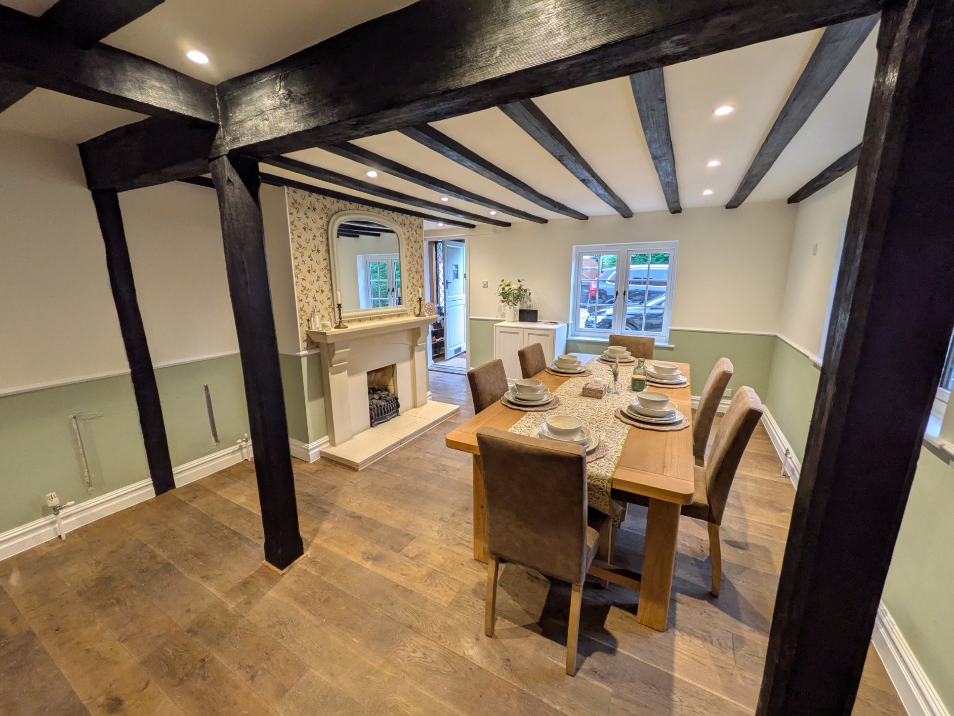 Renovated dining room with Farrow and Ball Vert de Terre panelling, Pointing walls, oak door, new skirting boards and restored ceiling beams